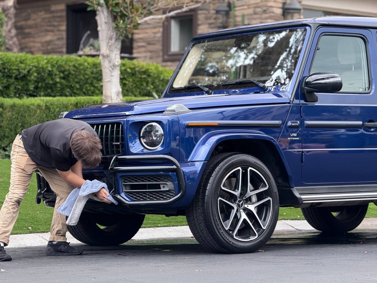 Blue Mercedes-AMG G-Class being detailed by hand