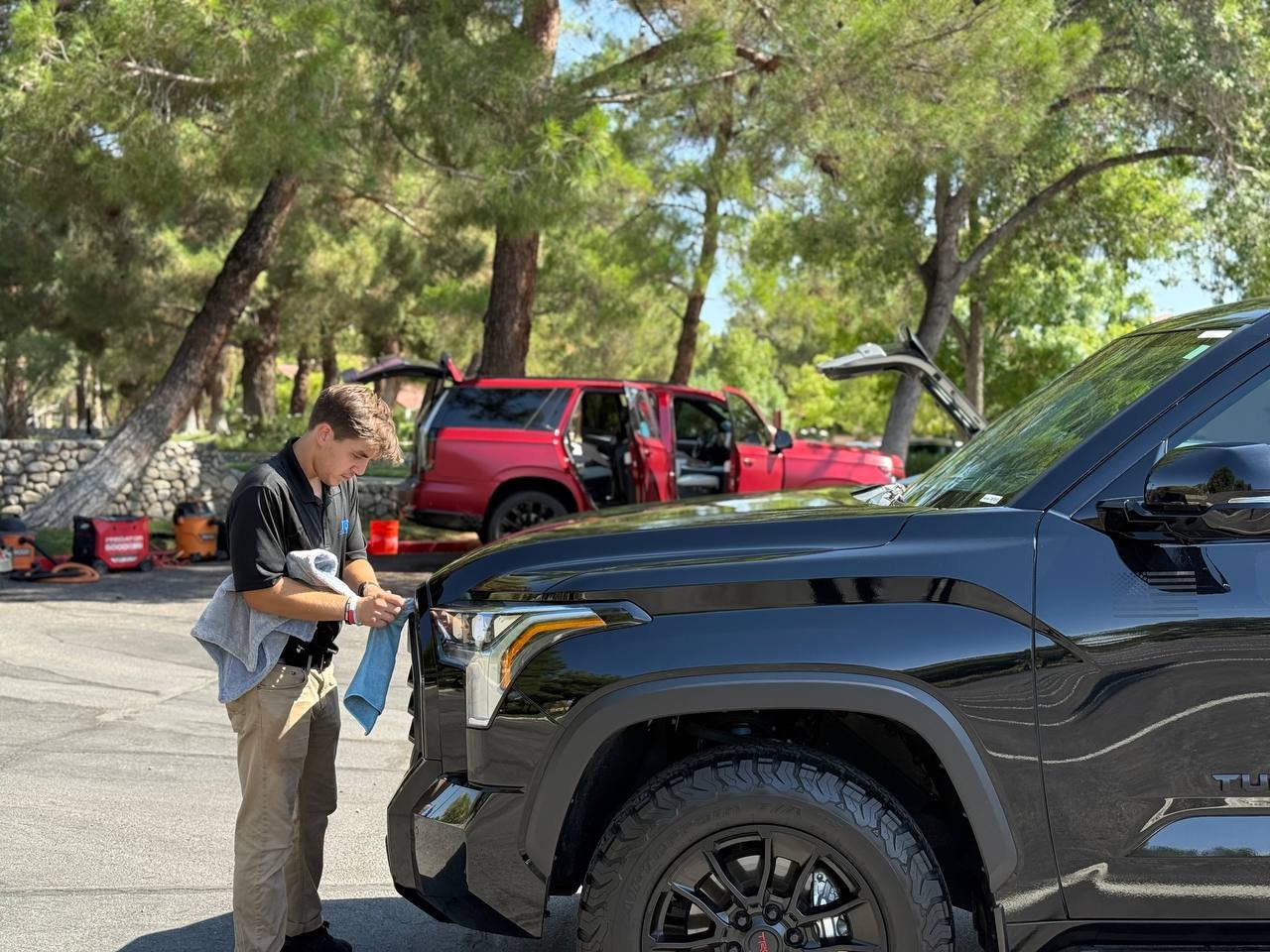 Technician detailing a black Toyota Tundra during mobile service
